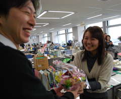 男性職員から花を贈られる女性職員=県庁