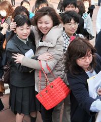 受験番号を見つけて喜ぶ受験生と家族=水戸市小吹町の水戸桜ノ牧高
