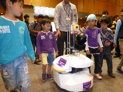 自律走行するロボットに付いて歩く子どもたち=つくば市竹園