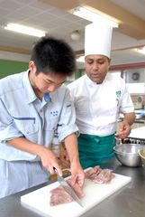 インド人シェフの指導を受けながらアカエイの調理に挑む海洋高生徒=ひたちなか市和田町3丁目