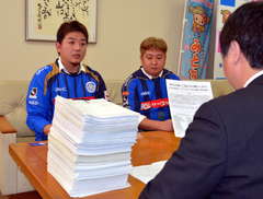 署名を提出する桜井謙一代表(左)=水戸市中央1丁目の市民会館