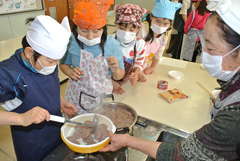 伝統の郷土食「赤もち」を調理する児童ら=坂東市立長須小学校