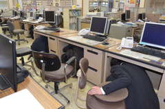 シェイクアウト訓練で机に隠れる行員たち=水戸市末広町の常陽銀行末広町支店