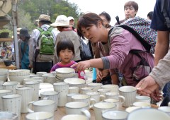 「笠間の陶炎祭」会場に並んだ焼き物を眺める来場者=笠間市笠間