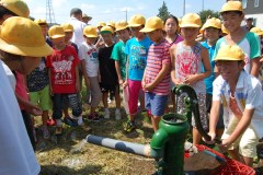 完成した手掘りの井戸から水をくむ児童たち=筑西市立大村小