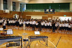 「校舎とのお別れ会」で全員で肩を組み校歌を歌う在校生と卒業生=鉾田市上冨田の市立鉾田北中学校体育館