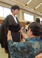 ボランティアに結城紬の着物を着せてもらう女子生徒=結城市立結城東中