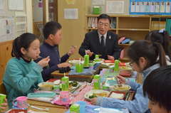 特別献立の給食を食べる児童と柿沼宜夫つくば市教育長=同市立竹園東小学校