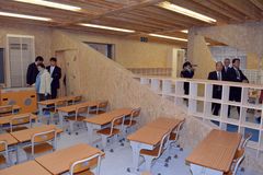 廊下側の壁が三角形に空いている教室を見学する内覧会の参加者=陽光台小