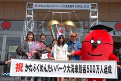 500万人目の来館者となった武田さん一家とパークキャラクター「タラコン博士」=大洗町磯浜町のかねふくめんたいパーク大洗