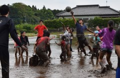 泥だらけになりながらバレーを楽しむ大学生や子どもたち=筑西市倉持