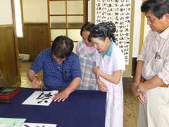 書作品の実演を見せる書家の中島鸞山さん=大子町の旧上岡小