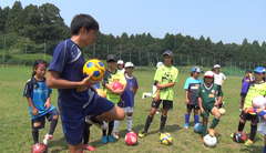 元Jリーガーの楠瀬章仁さんからリフティングの指導を受ける女子児童=水戸市のJA県農村研修館