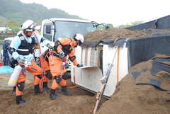 土砂崩れに巻き込まれて横転した車両の運転手救助に取り組む消防署員=桜川市岩瀬