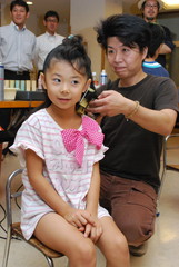 おしゃれに髪型をセットしてもらう園児=常陸太田市木崎二町