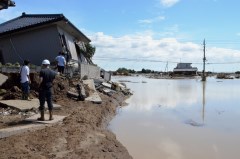 地面が大きくえぐられた堤防決壊現場。濁流が流入した市街地側を望むと、破壊された住宅が点在していた=11日午前11時半、常総市三坂町