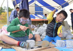 のみを使い石材加工に挑戦する子どもたち=笠間芸術の森公園イベント広場