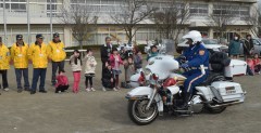 「スクールガード河間」10周年記念イベントで走行披露する県警白バイ隊=筑西市立河間小