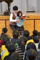 松尾賛之さんと一緒にバイオリンを弾く児童=水戸市立稲荷第一小