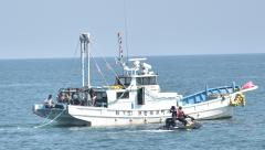 サメ対策の防護網を設置する町漁協組合員=大洗沖