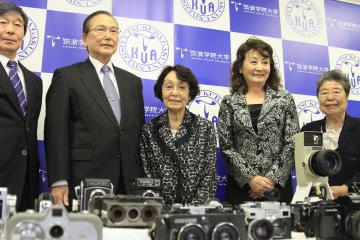 歴史的価値のあるカメラを筑波学院大に寄贈した朝倉愛子さん(中央)=つくば市吾妻の同大