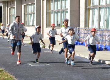 児童とともにコースを走る田山寛豪さん(左)=大洗町磯浜町