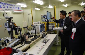 完成した模擬スマート工場でロボットを視察する橋本昌知事と関係者=茨城町長岡
