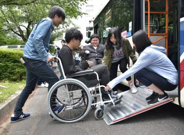 車椅子でバスの乗降体験する学生たち=水戸市文京