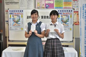 自分宛ての選挙メッセージはがきを手にする久保田真央さんと斎藤留菜さん(左から)=水戸市三の丸