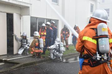 放水活動とともに要救助者の救出に向かう参加者=茨城町長岡の県立消防学校