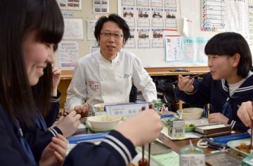 中学生と一緒に自らが監修した給食を食べる眞中秀幸さん(中央)=潮来市潮来