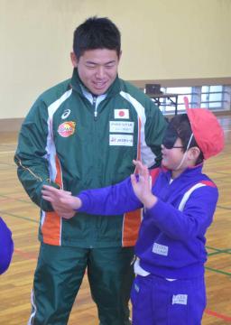 視覚障害を体験するためのアイマスクをした児童と触れ合う山口凌河さん=取手市立山王小