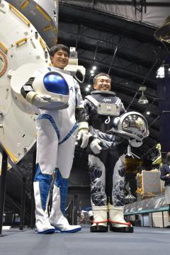 学生がデザインした宇宙服を着用した宇宙飛行士の大西卓哉さん(左)と若田光一さん=つくば市千現