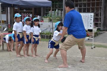 熊田栄副会長を押しながら相撲の基本動作を習う園児=高萩市下手綱