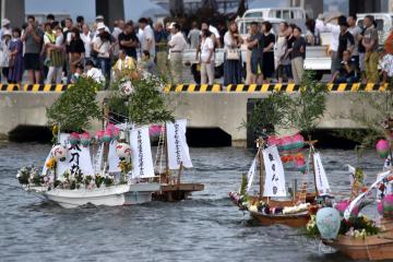 み霊を乗せた盆船が漁船に引かれながら漁港内を巡った=北茨城市の大津漁港