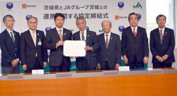 県とJAグループ茨城が初めて連携協定を締結し、協定書にサインした大井川和彦知事(左から3人目)と佐野治会長(中央)=県庁