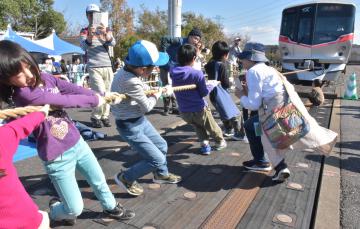 車両の綱引きに挑戦する子どもたち=つくばみらい市筒戸のTX総合基地