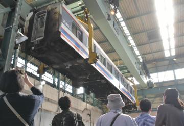 大型クレーンでつり上げられた重量30トンの車両=常総市水海道高野町の水海道車両基地