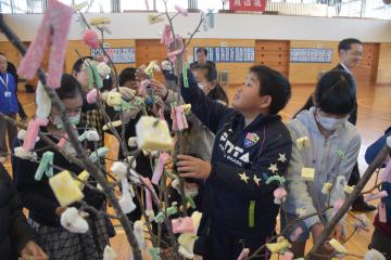 「まゆ玉つくり会」で、桜の木に餅を付ける児童=東海村照沼