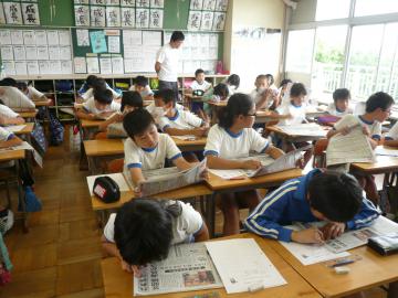 当日の茨城新聞を見ながら「題字のひみつ」を探る児童たち=八千代町立西豊田小
