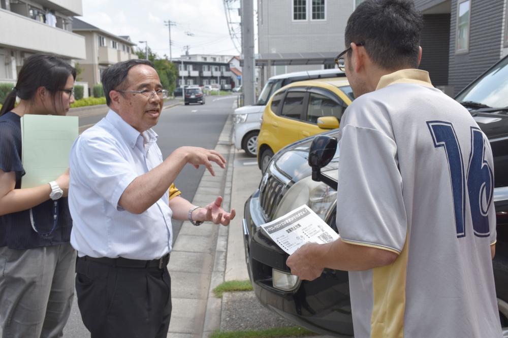 住宅を訪問し、車の防犯対策を呼び掛けるつくば中央署員(左)=つくば市学園の森