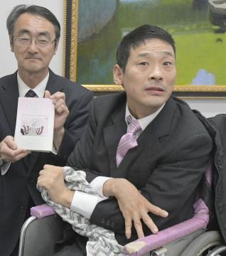 3冊目の詩集を完成させた藤枝利教さん(右)と詩集を送られた日立市学校長の塚本秀樹会長=市役所