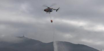 上空から散水する県防災ヘリコプター=つくば市北条