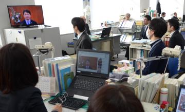 テレビやパソコンの画面を通して大井川和彦知事の訓示に耳を傾ける県職員ら=県庁