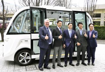 自動走行バスの前で記念撮影する境町の橋本正裕町長(中央)ら=東京都港区