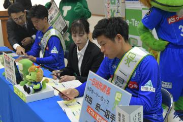 スマートフォンを使った確定申告書作成を体験する村田航一選手(右)=城里町小勝