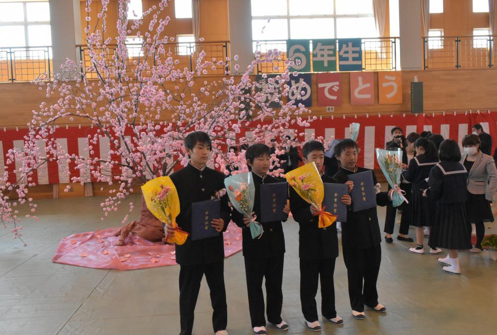 桜の木の前で記念写真に納まる卒業生たち=城里町立石塚小学校
