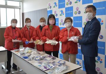 小田川浩つくばみらい市長(右端)にマスクを手渡すボランティア団体メンバー=同市役所