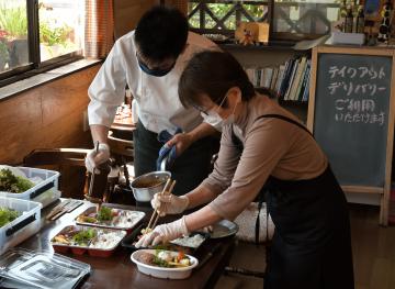 デリバリー用の弁当を盛り付けるレストランドルチェの伊井正徳さん(左)と母の照子さん=利根町羽根野