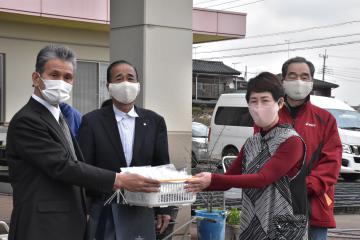 鈴木秋夫さん、君子さん夫妻(右から)から寄贈マスクを受け取る塩森茂郎会長(左端)=結城市小田林